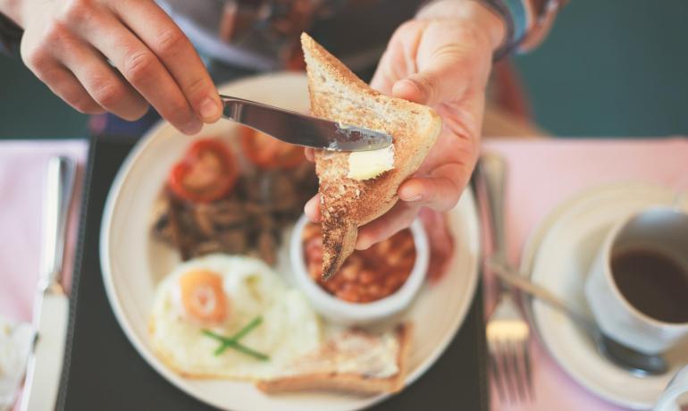 Colazione con toast, uova, fagioli e caffè.