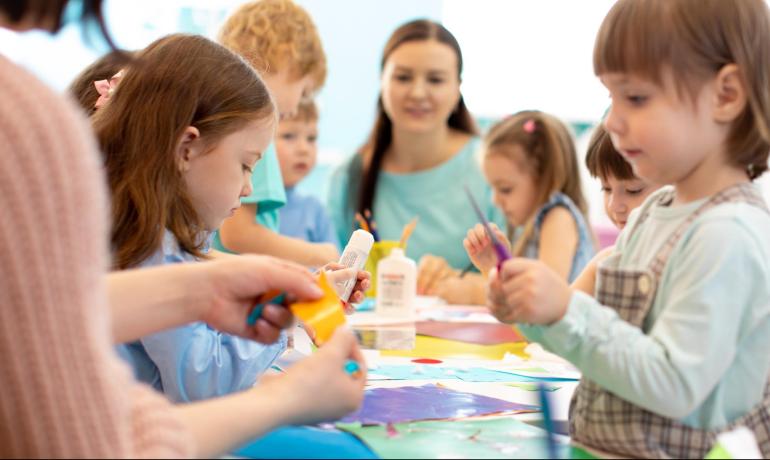 Bambini che fanno attività artistiche in classe con l'insegnante.